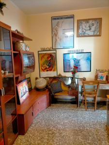 Sleep In Sicily في سيراكوزا: غرفة معيشة مع مكتب وكرسي وصور على الحائط