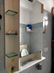 uma casa de banho com um WC e um espelho. em Sleep In Sicily em Siracusa