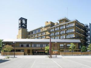 un aparcamiento vacío frente a un edificio con una torre de reloj en Fuji Hanayagi no Sho Keizan, en Fuefuki