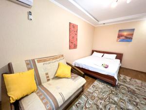 キーウにあるApartments on Pecherskのベッド2台とソファが備わる小さな客室です。