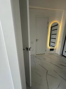 an empty hallway with marble floors and an open door at ЖК Комсомольский in Taldykolʼ