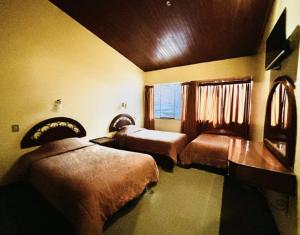 ein Hotelzimmer mit 2 Betten und einem Fenster in der Unterkunft Hotel Los Portales in Huaraz