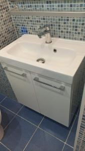un lavandino bianco in un bagno con piastrelle blu di APCOSTAS - Puerto Simona a Roses