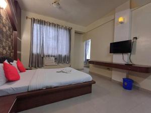 a bedroom with a bed with a television and a window at Hotel Elegant in Dimāpur