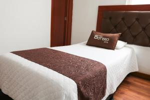 Una cama con una almohada marrón encima. en Hotel Casa Botero 101 en Bogotá