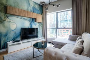 a living room with a couch and a tv at Seaside, renewed poshy apartment on JBR in Dubai