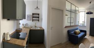 a kitchen with a table and a blue chair at LaViDaViò Suite Room in Bergamo
