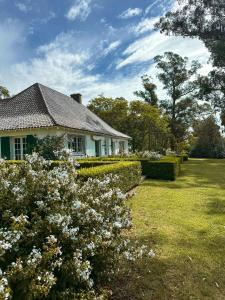 a white house with flowers in the yard at Estancia Ave María in Tandil