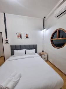 a bedroom with a white bed and a mirror at Madi Betong Homestay (มาดีเบตง) in Betong