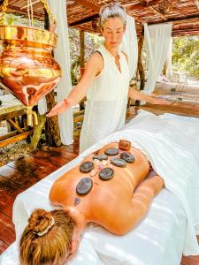 a woman standing next to a bed with a body on it at Hotel Gavia - Rio y Mar in Palomino