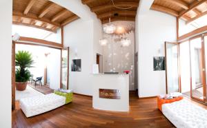 a living room with white furniture and windows at Tre Merli Beach Hotel in Trieste