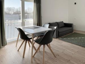 a living room with a table and chairs and a couch at Board Inn - Haus Regensburg in Regensburg