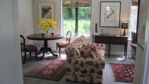 a living room with a chair and a table at Rose Cottage at The Elms in Christchurch
