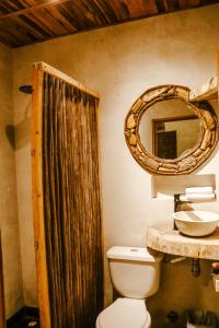 a bathroom with a toilet and a sink and a mirror at Hotel Gavia - Rio y Mar in Palomino