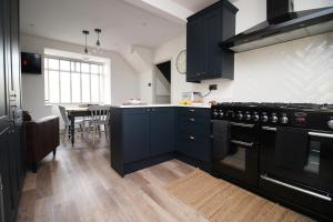 a kitchen with black appliances and a dining room at Countryside Gem - Tranquil Escape in Bath in Bath