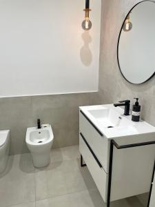 ein Badezimmer mit einem WC, einem Waschbecken und einem Spiegel in der Unterkunft Baaria house in Bagheria