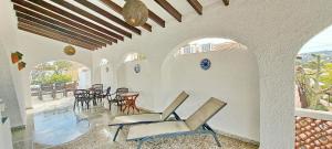 a room with chairs and tables and a patio at Villa Sol in Moraira