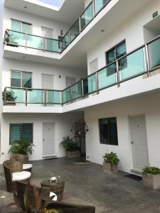 an empty building with a balcony and tables and chairs at Quinta Santa Anita in Playa del Carmen