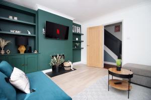 - un salon avec des murs verts et un canapé bleu dans l'établissement Countryside Gem - Tranquil Escape in Bath, à Bath