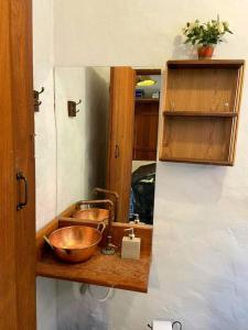 - une cuisine avec un évier et un bol en bois dans l'établissement Casinha do Milho - Visual único!, à Milho Verde
