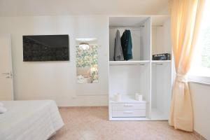 a white bedroom with a bed and a closet at Casetta Geró in Ischia