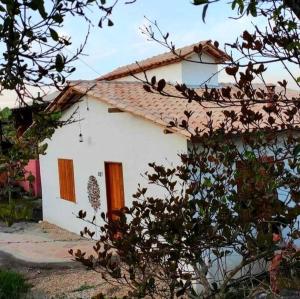 une petite maison blanche avec un toit rouge dans l'établissement Casinha do Milho - Visual único!, à Milho Verde