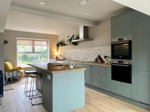 a kitchen with green cabinets and a counter top at Beautiful 3 Bedroom Home, North Cornwall in Saint Teath