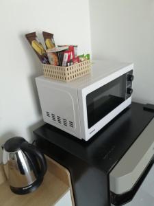 a microwave on a black counter with a basket of utensils at Phuket naka condon-52-45 免费高速上网免费停车 in Phuket