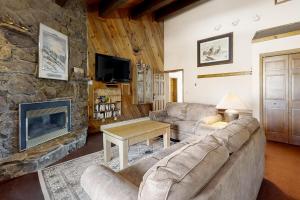 Una sala de estar con un sofá y una chimenea. en Phoenix 216, en Steamboat Springs
