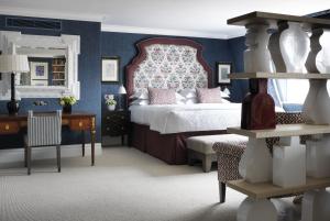 een slaapkamer met een bed, een bureau en een stoel bij Charlotte Street Hotel, Firmdale Hotels in Londen