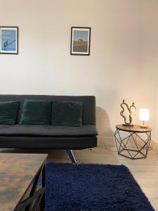 a living room with a black couch and a table at Cosy Prenton home near Tranmere Club and Liverpool in Birkenhead