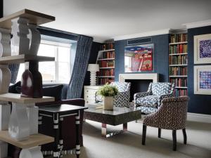 a living room with blue walls and a table and chairs at Charlotte Street Hotel, Firmdale Hotels in London