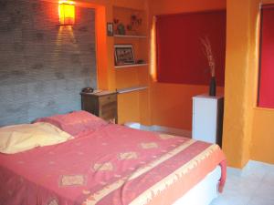 una camera con un letto con una parete rossa e gialla di Saint-Raphaël Villa mitoyenne 10 min de la plage a Saint-Raphaël