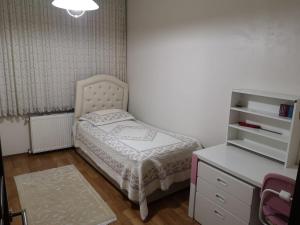 um pequeno quarto com uma cama e uma cómoda em Beşirli Luxury Apartments em Trabzon