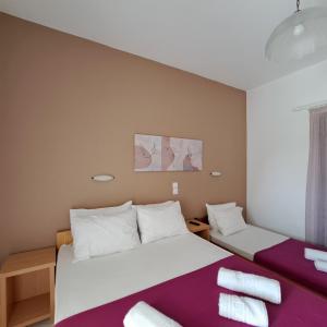 dwa łóżka w pokoju fioletowo-białym w obiekcie Studio Stars w Laganas