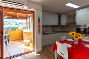 una cocina con una mesa con un mantel rojo. en Portisco Living en Marina di Portisco