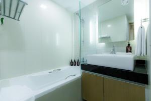 y baño con bañera, lavamanos y bañera. en Citadines Sukhumvit 8 Bangkok, en Bangkok