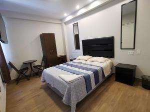 a bedroom with a bed with a blue and white blanket at Hotel Sol de Marcona in San Juan