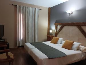 ein Schlafzimmer mit einem großen Bett und einem Fenster in der Unterkunft Hotel Rural los Tadeos in Zahara de la Sierra