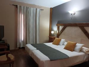 a bedroom with a large bed and a window at Hotel Rural los Tadeos in Zahara de la Sierra