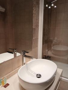 y baño con lavabo blanco y bañera. en Hotel Rural los Tadeos, en Zahara de la Sierra