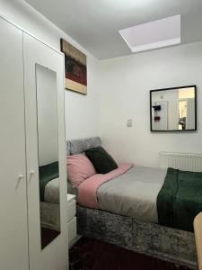 a bedroom with a bed and a mirror at Home Away in London
