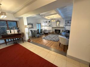 a living room with a piano and a dining room at The Kings Head Country Hotel in Great Bircham