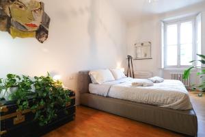 um quarto com uma cama e uma planta em vaso em Primopiano - Ugo Bassi em Milão