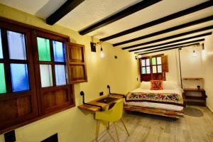Schlafzimmer mit einem Bett, einem Schreibtisch und Fenstern in der Unterkunft Casa Moline Blue in Bogotá
