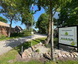 a sign next to a road with a house at Safaritent Suikerpeer in Ruinerwold