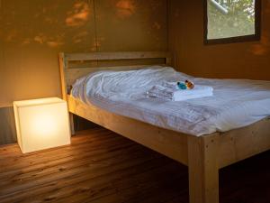 a bed with a teddy bear sitting on top of it at Safaritent Suikerpeer in Ruinerwold