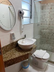 a bathroom with a sink and a toilet and a mirror at Mirante Hotel in Santa Vitória do Palmar