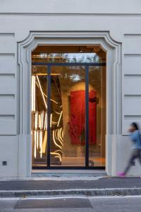 una persona che cammina davanti alla finestra di un negozio di AR Suites&Art a Bergamo