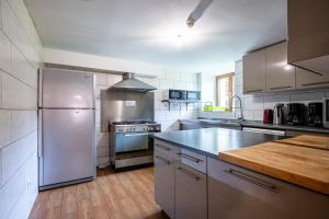 a large kitchen with stainless steel appliances and wooden floors at Gite St Joseph gitesdes2vallees in Ventron